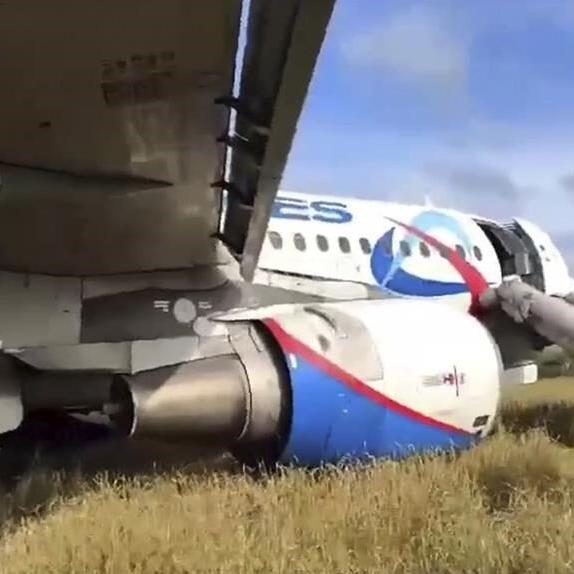 A Russian passenger jet with a hydraulics problem makes a safe emergency landing in an open field
